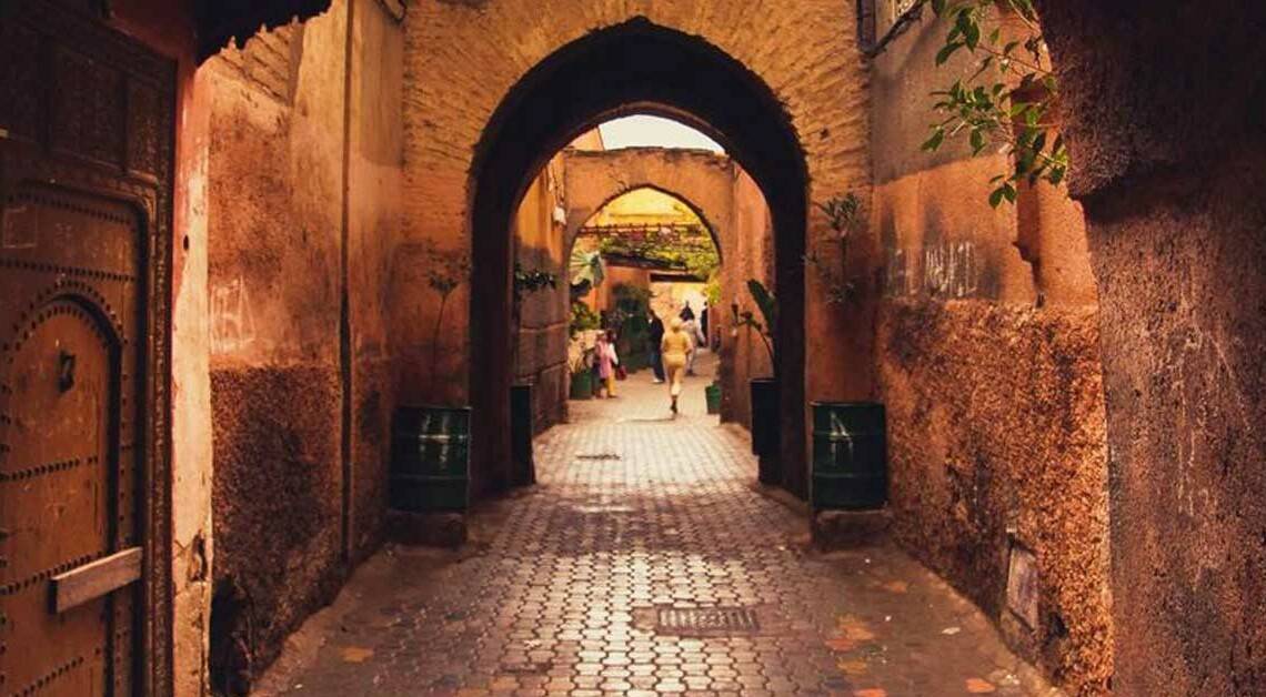 Une ruelle étroite avec des arches et une porte dans la médina, la vieille ville de Marrakech