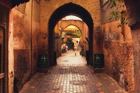 Une ruelle étroite avec des arches et une porte dans la médina, la vieille ville de Marrakech