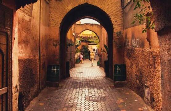 Une ruelle étroite avec des arches et une porte dans la médina, la vieille ville de Marrakech